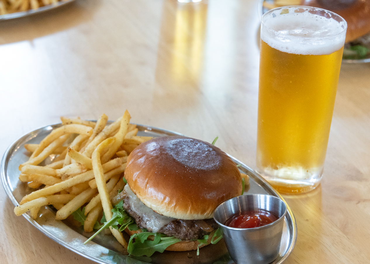 Burger and fries with a beer on a wooden table