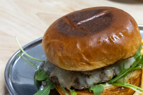 Burgers and fries on metal plates on a wooden table